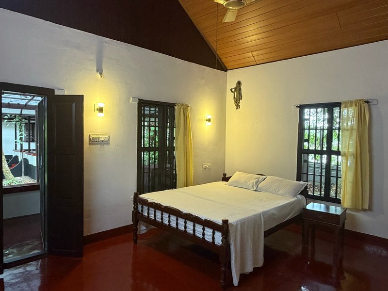 Guest bedroom with wooden bed at Gowrisankara Kerala